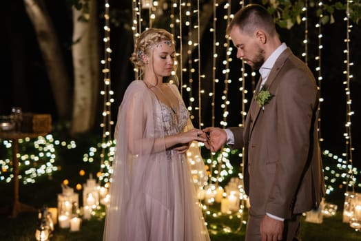 night wedding ceremony of the newlyweds in a country cottage on a green hill