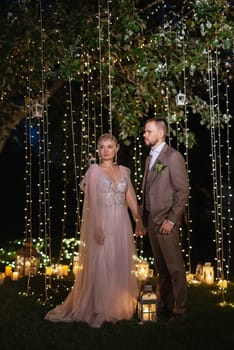 night wedding ceremony of the newlyweds in a country cottage on a green hill