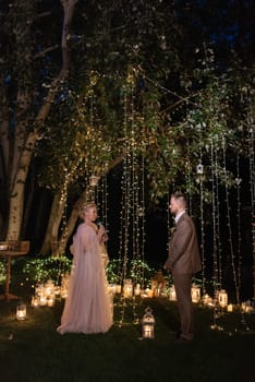 night wedding ceremony of the newlyweds in a country cottage on a green hill