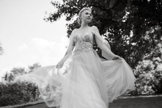 portrait of a happy bride in a light light dress on a green meadow in the park wearing elven accessories