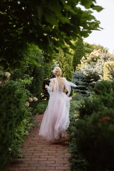 portrait of a happy bride in a light light dress on a green meadow in the park wearing elven accessories