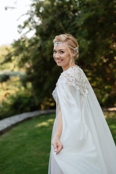 portrait of a happy bride in a light light dress on a green meadow in the park wearing elven accessories