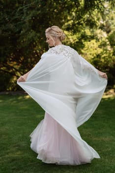 portrait of a happy bride in a light light dress on a green meadow in the park wearing elven accessories