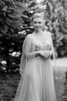 portrait of a happy bride in a light light dress on a green meadow in the park wearing elven accessories