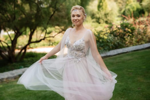 portrait of a happy bride in a light light dress on a green meadow in the park wearing elven accessories