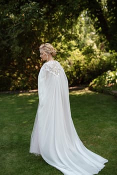 portrait of a happy bride in a light light dress on a green meadow in the park wearing elven accessories