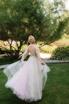 portrait of a happy bride in a light light dress on a green meadow in the park wearing elven accessories