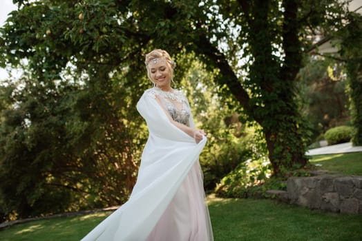 portrait of a happy bride in a light light dress on a green meadow in the park wearing elven accessories