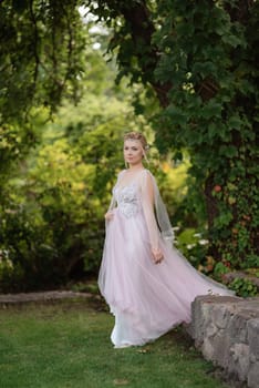 portrait of a happy bride in a light light dress on a green meadow in the park wearing elven accessories