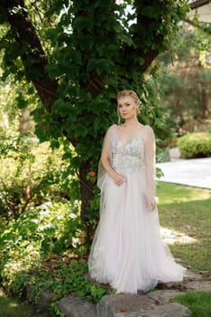 portrait of a happy bride in a light light dress on a green meadow in the park wearing elven accessories