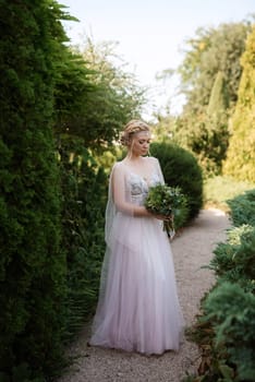 portrait of a happy bride in a light light dress on a green meadow in the park wearing elven accessories