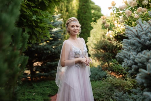 portrait of a happy bride in a light light dress on a green meadow in the park wearing elven accessories