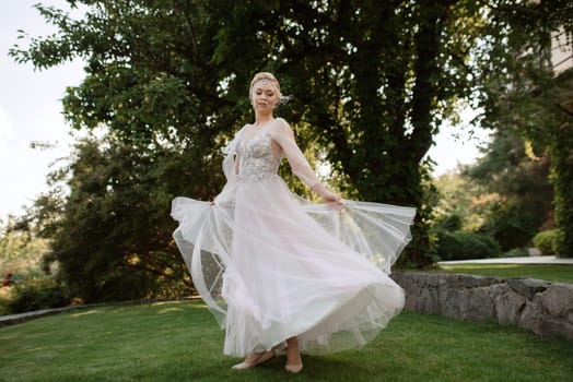 portrait of a happy bride in a light light dress on a green meadow in the park wearing elven accessories