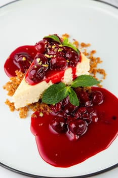 side view of cheesecake with juicy berries and mint