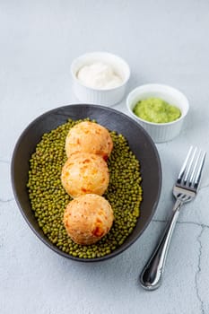 cooked meatballs on peas in an oblong bowl