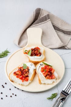 bruschetta with tomatoes and labneh cheese on a light background