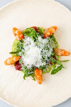 beautifully served shrimp with arugula and grated cheese