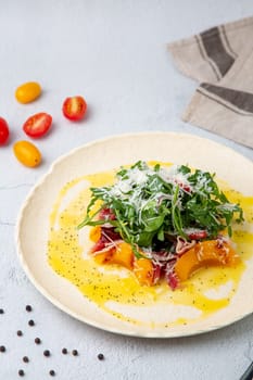 green salad with arugula and lingonberries on a white plate and marble background