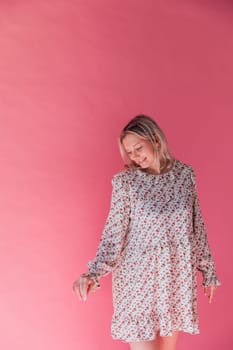 blonde woman in summer dress on pink background