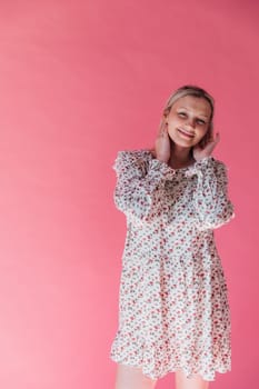 blonde woman in summer dress on pink background