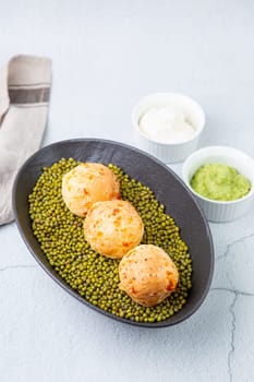 cooked meatballs on peas in an oblong bowl