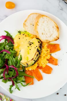 a mix of salmon, arugula salad, white bread and baked avocado with cheese