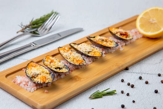 oysters scallops with red sea salt and citric acid on a wooden tray