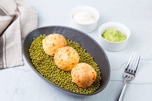 cooked meatballs on peas in an oblong bowl