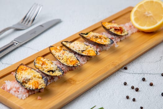 oysters scallops with red sea salt and citric acid on a wooden tray