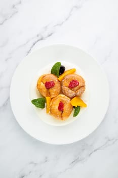 muffins with peach, raspberry, black berry and mint covered with powdered sugar