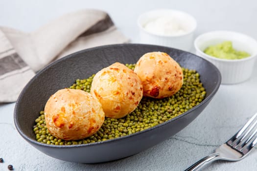 cooked meatballs on peas in an oblong bowl