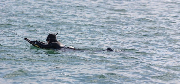 Underwater hunter preparing to dive. Fishing on sea - telephoto