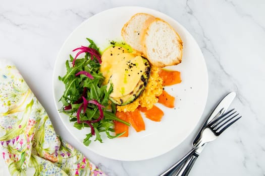 a mix of salmon, arugula salad, white bread and baked avocado with cheese