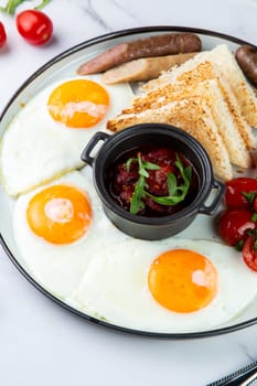 Breakfast of eggs and vegetables with cherry tomatoes and slices of bread