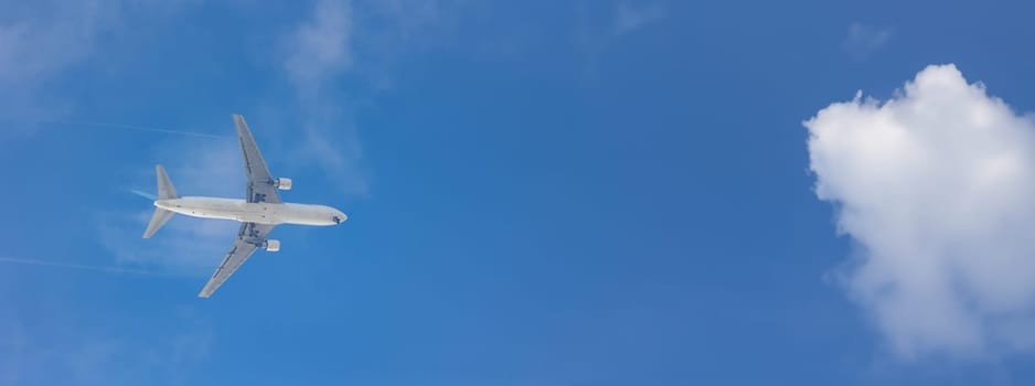 An airplane is flying in the blue sky