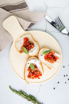 bruschetta with tomatoes and labneh cheese on a light background