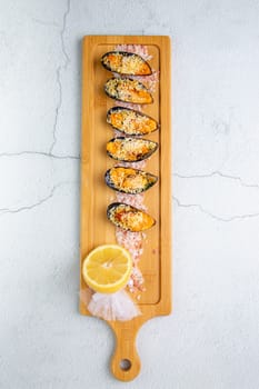 oysters scallops with red sea salt and citric acid on a wooden tray