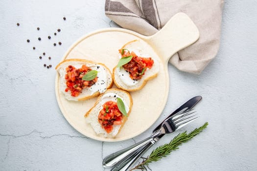 bruschetta with tomatoes and labneh cheese on a light background