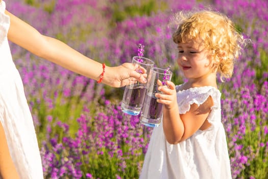 Children in a lavender field drink lemonade. Selective focus. Nature.