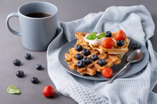 Delicious waffles with whipped cream, strawberries and blueberries.