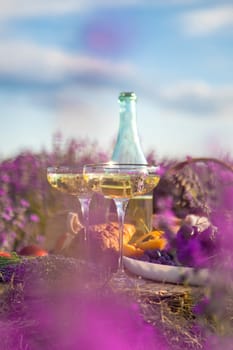 Picnic with wine in a lavender field. Selective focus. Nature.