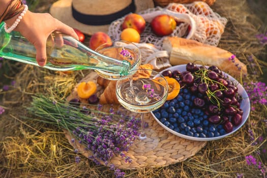 A woman drinks wine in a lavender field. Selective focus. Nature.