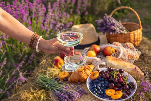 A woman drinks wine in a lavender field. Selective focus. Nature.