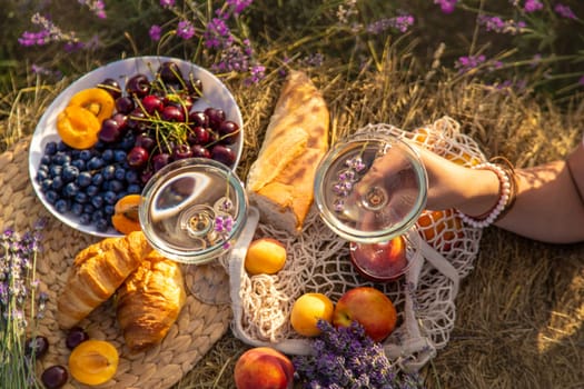 A woman drinks wine in a lavender field. Selective focus. Nature.