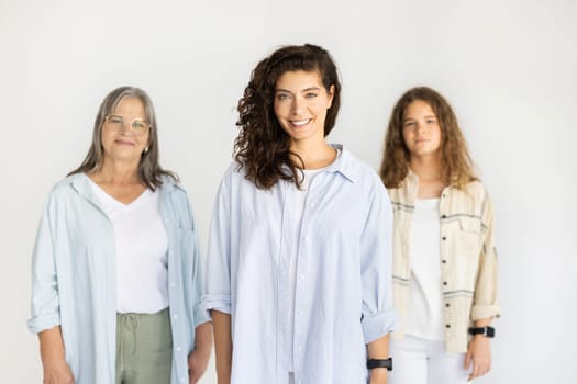 Happy caucasian teen girl, adult mom and old woman in casual look at camera, enjoy lifestyle, isolated on white studio background. Genetic, female generation, relationship and family