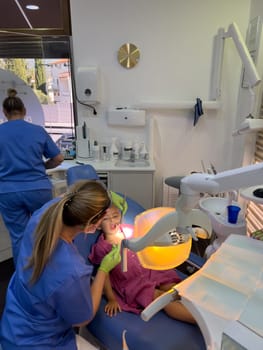 Dentist examining a little girl sitting in a dental chair. High quality photo