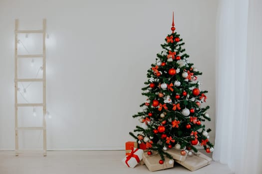 Christmas tree in a white room with a Christmas greeting gifts 2018