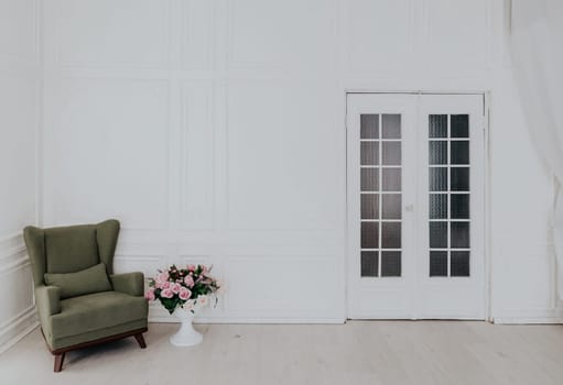 Green Chair in a white room with a door 1