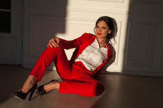 Portrait of a woman in a red business suit on the floor