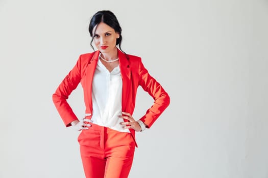 Portrait of a woman in a red business suit in a white room